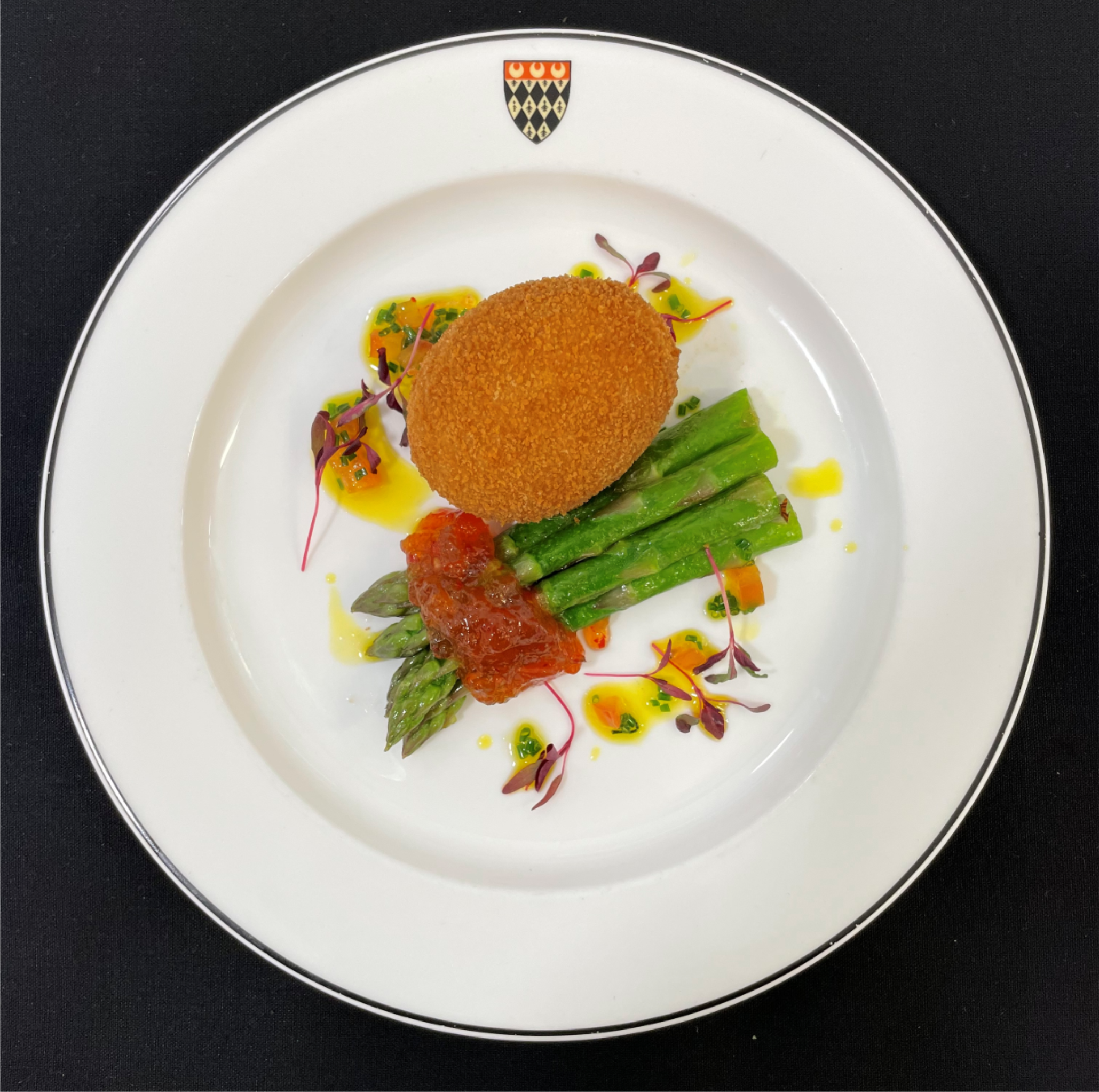 Asparagus (v) served with a crispy duck egg and dressed with a chive oil