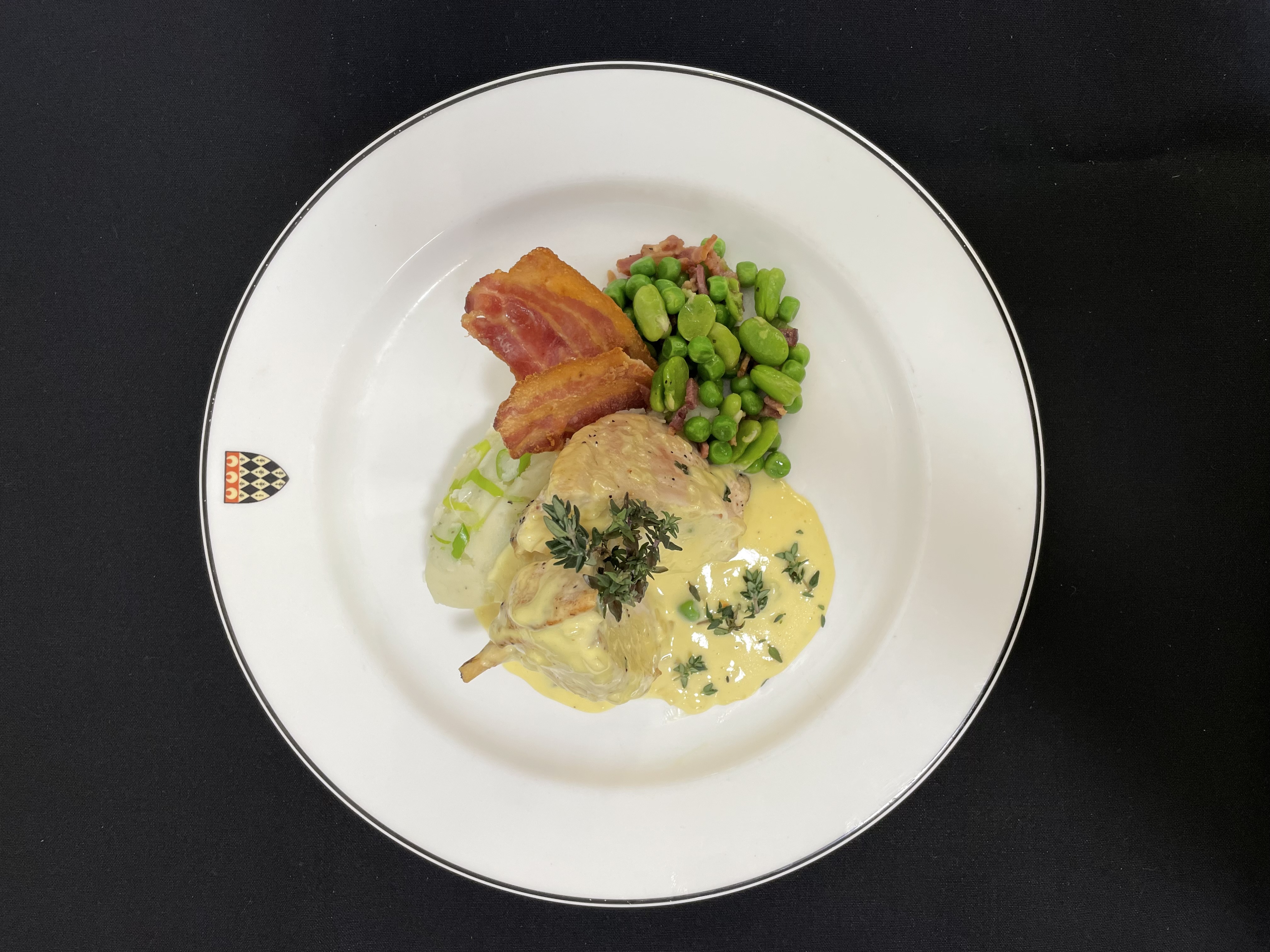 British chicken suprème served with a leek and mushroom mousse, spring onion mash, peas, broad beans, Gloucester old spot bacon and beurre blanc sauce